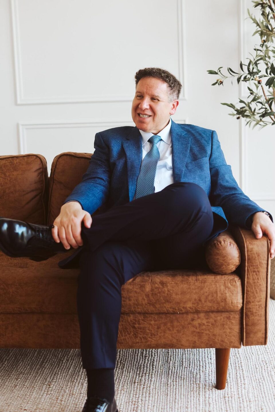 Attorney Carlos Maury, a former U.S. Immigration Judge, seated in a navy suit.